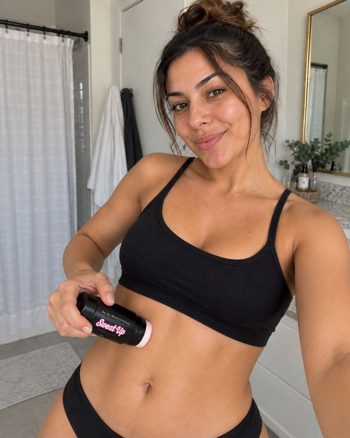 Femme tenant le stick de sudation Sweat'up MWT dans sa salle de bain