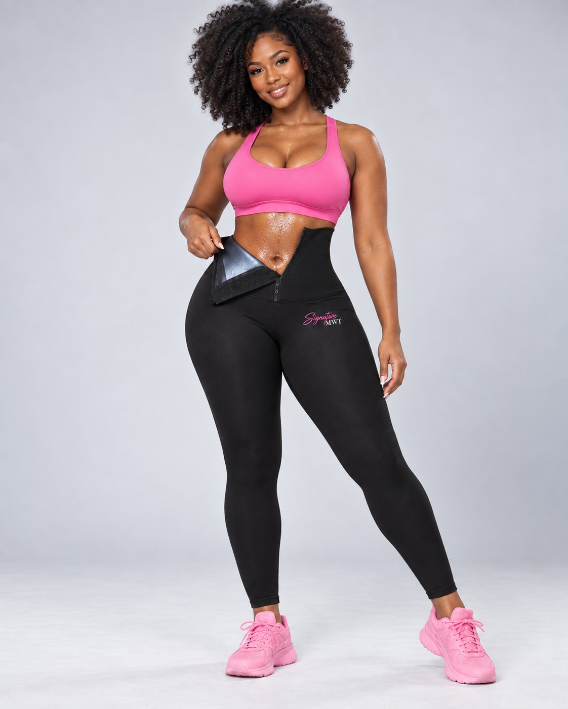 Femme portant le legging de sudation MWT noir et ouvrant la ceinture taille haute, avec une brassière rose